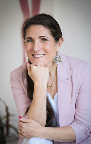 A woman wearing a pink jacket and white pants. Beschreibung von KI generiert